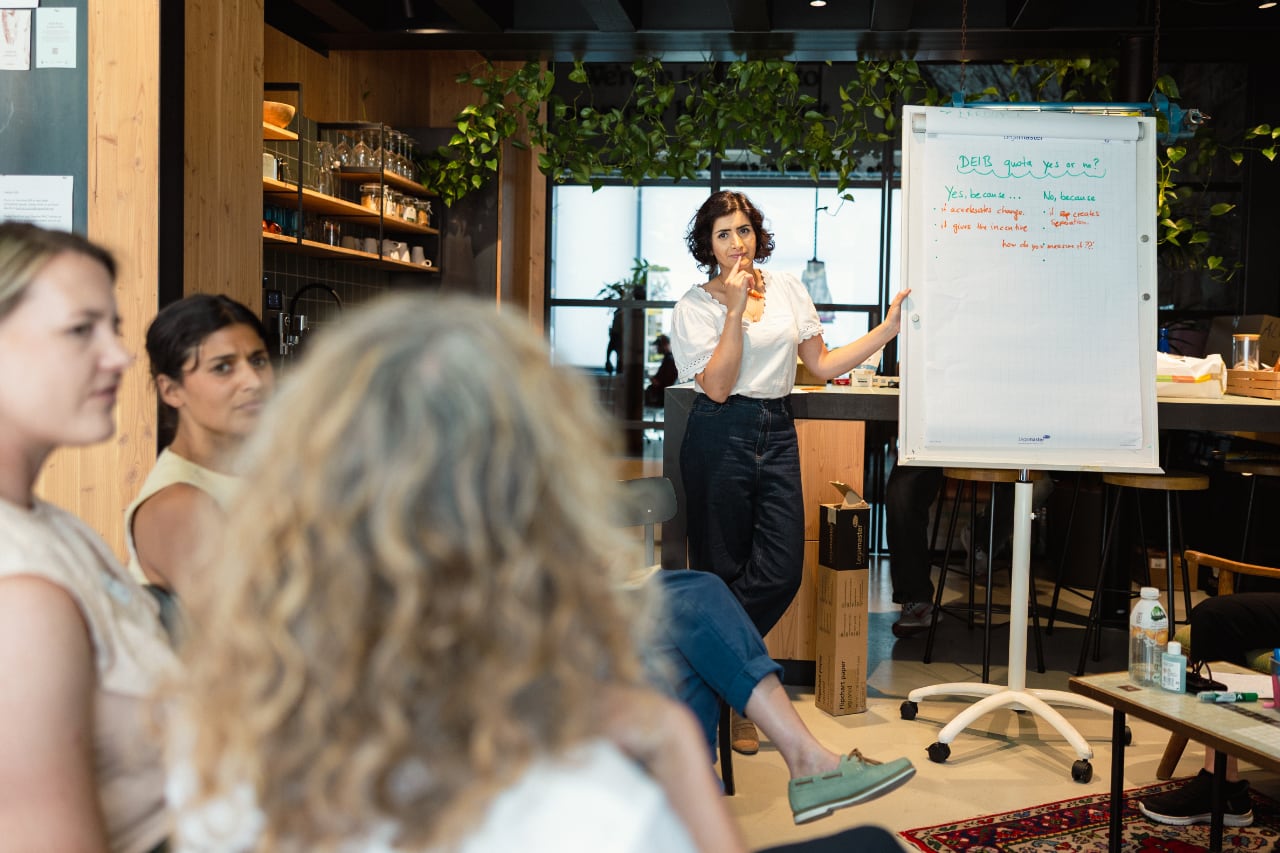 Sahar Gasgari-Luu steht an einem Flipboard und diskutiert mit den Frauen im Publikum